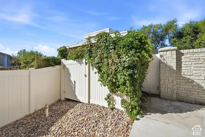 Privacy fencing with a secure gate, complemented by a stone wall