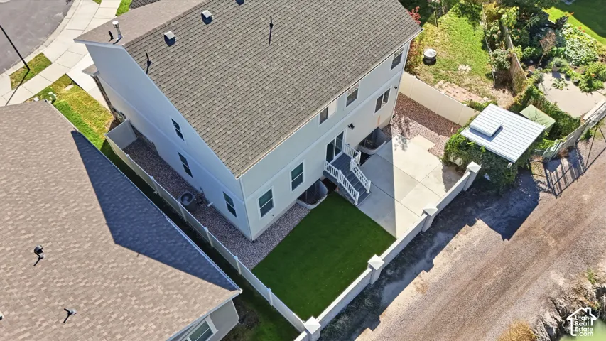Backyard featuring a concrete patio, artificial turf lawn, and a privacy fence