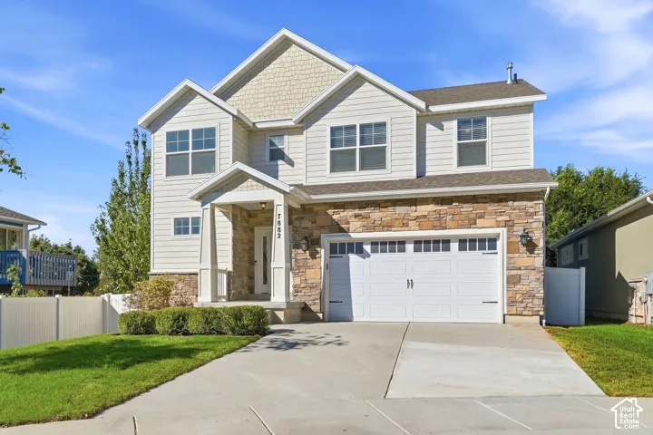Two-story residence featuring light-colored siding and stone veneer accents