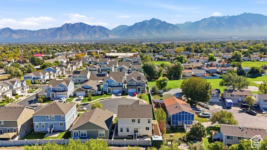 Residential neighborhood with varied architectural styles, mature landscaping, and mountain backdrop
