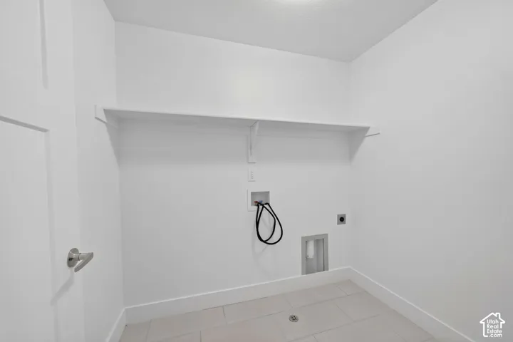 White painted walls, tile flooring, and a single wall-mounted shelf