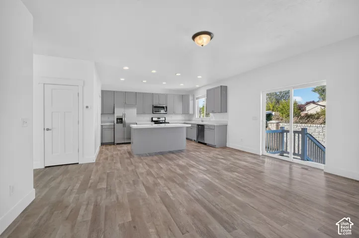 Open-concept living area featuring wood-finish flooring, recessed lighting, and a sliding glass door