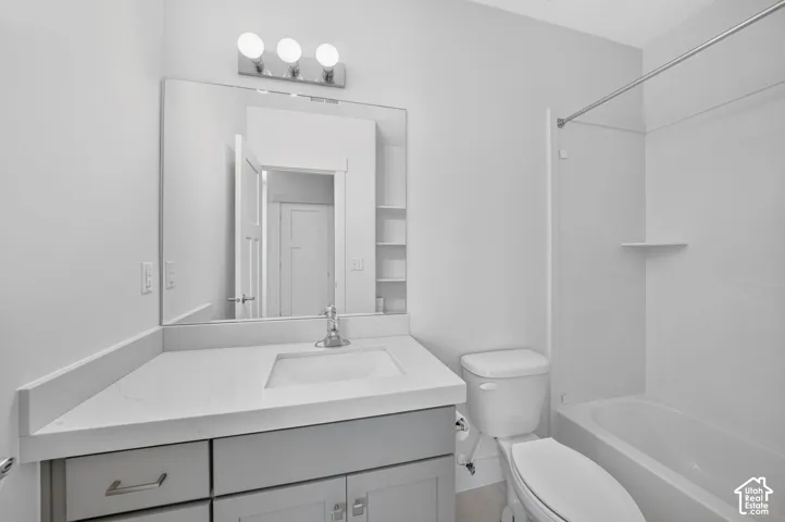 Vanity with integrated sink, chrome faucet, and expansive wall mirror