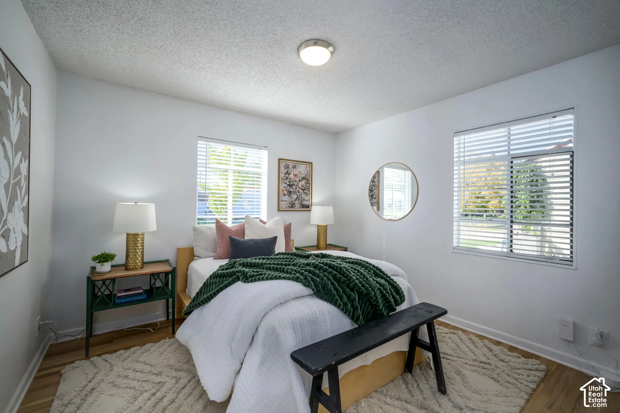 Wood-finish flooring, white walls, and two windows with horizontal blinds