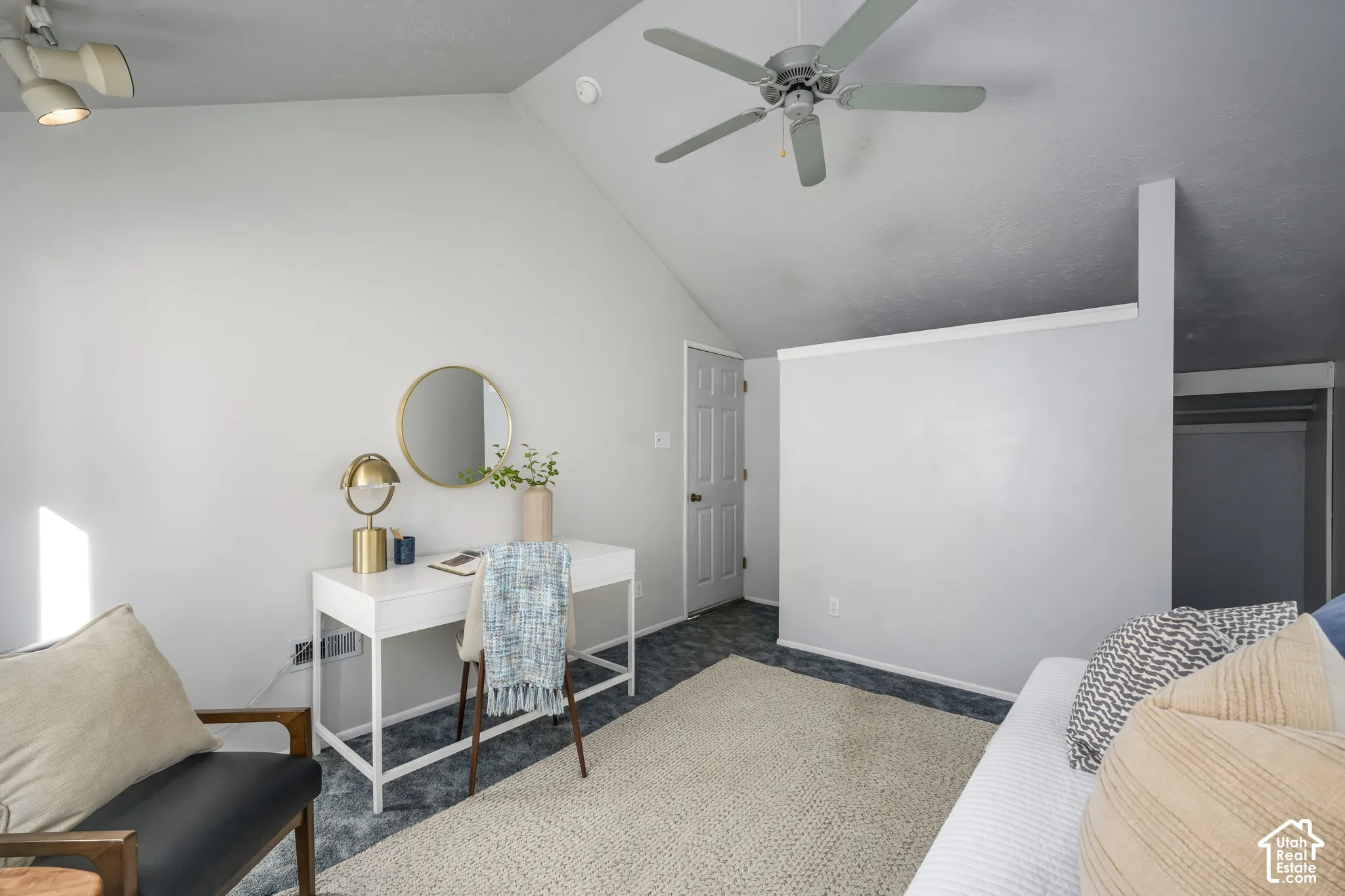 Vaulted ceiling with a ceiling fan, track lighting, and a solid door