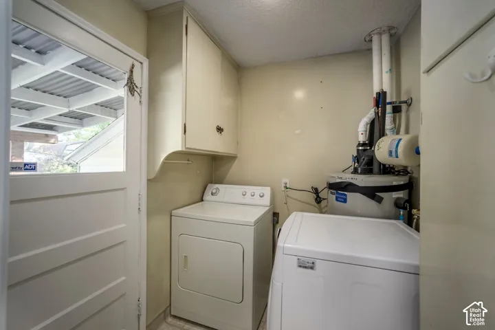 White panel door with upper glass panel, built-in upper cabinetry, and tile flooring