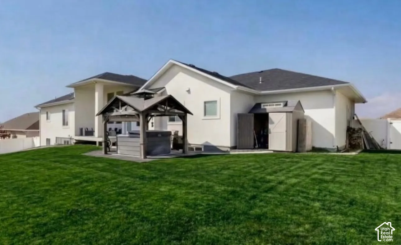 Expansive lawn with a built-in outdoor structure, a deck, and an exterior storage shed