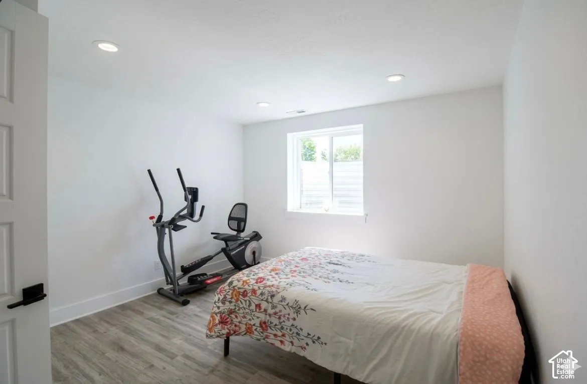 Wood-finish flooring, white walls, and recessed lighting