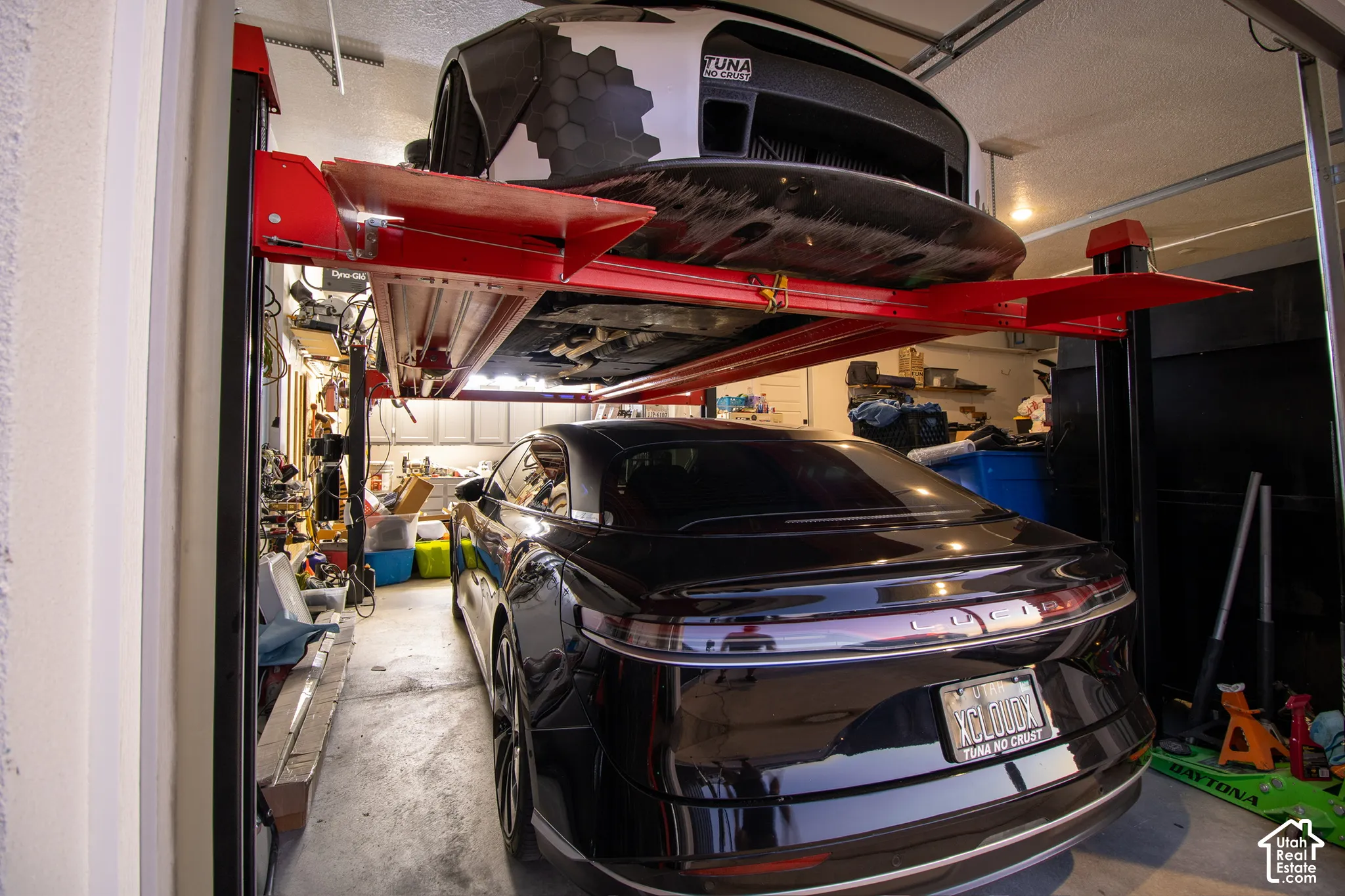 Garage featuring a vehicle lift system, concrete flooring, and built-in shelving
