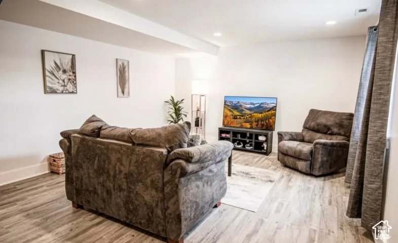Recessed lighting illuminates the white walls and wood-finish flooring