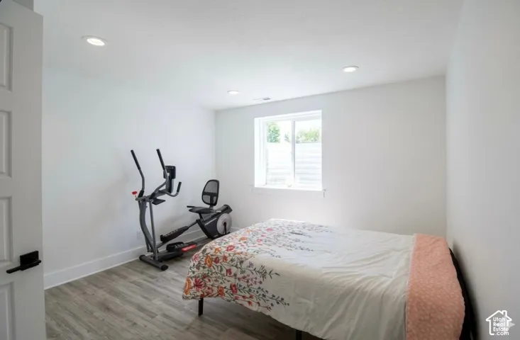 Wood-finish flooring, white walls, and recessed lighting