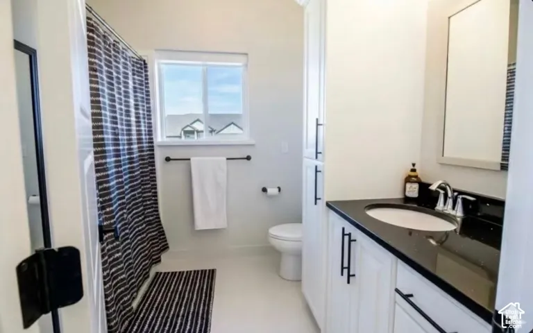 White vanity with black countertop, inset sink, and chrome faucet