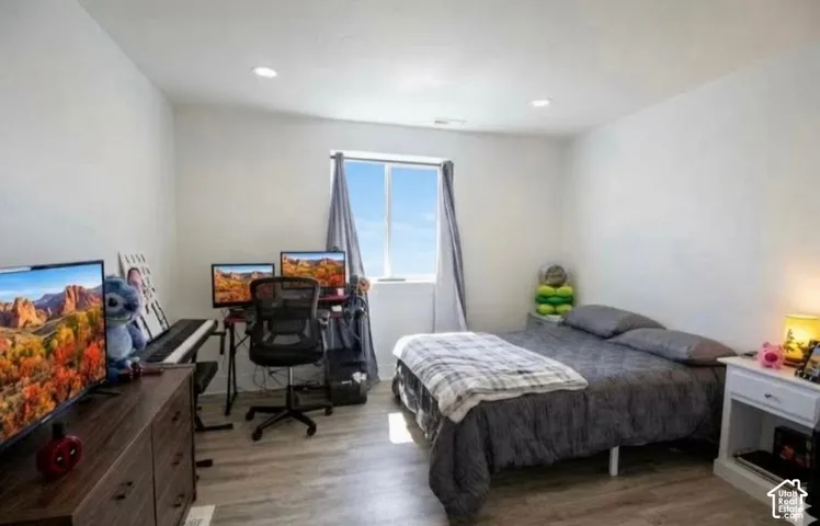 Recessed lighting, wood-finish flooring, and a window with natural light