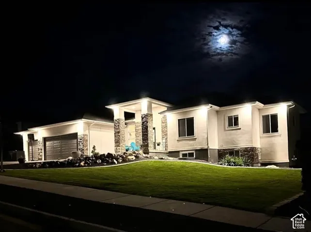 Stucco exterior with stone accents, illuminated by exterior lighting