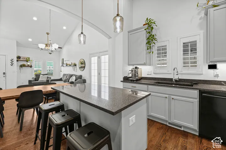 Vaulted ceilings, wood-finish flooring, light gray cabinetry, dark speckled countertops, and French doors