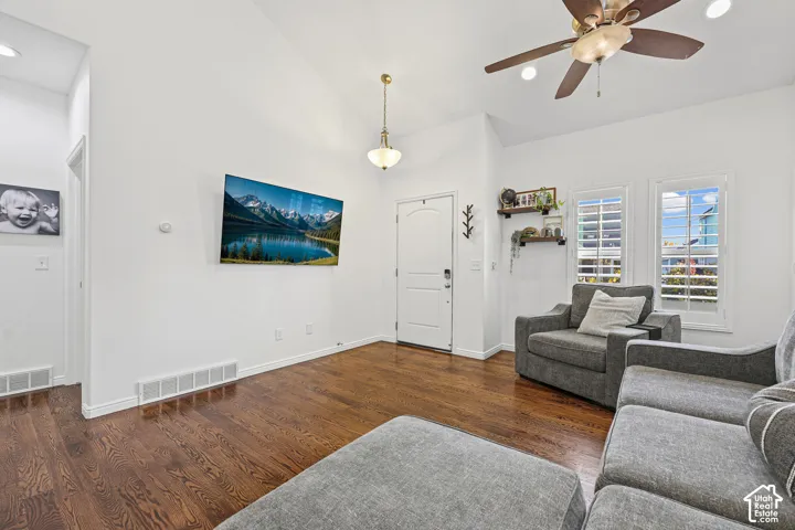 Vaulted ceiling with a ceiling fan, recessed lighting, and wood-finish flooring