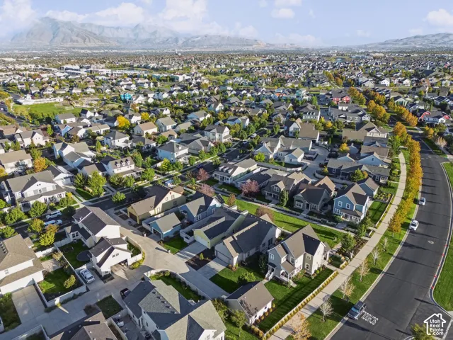 Residential neighborhood with varied architectural styles, mature landscaping, and mountain backdrop