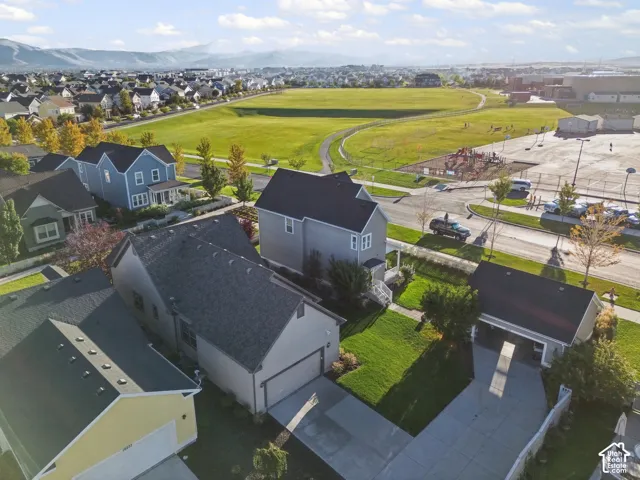 Aerial perspective showcasing a residential area with a large green space, a playground, and multiple homes