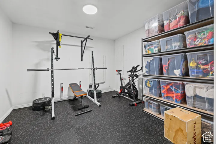 Rubber mat flooring, white painted walls, overhead lighting, and built-in shelving
