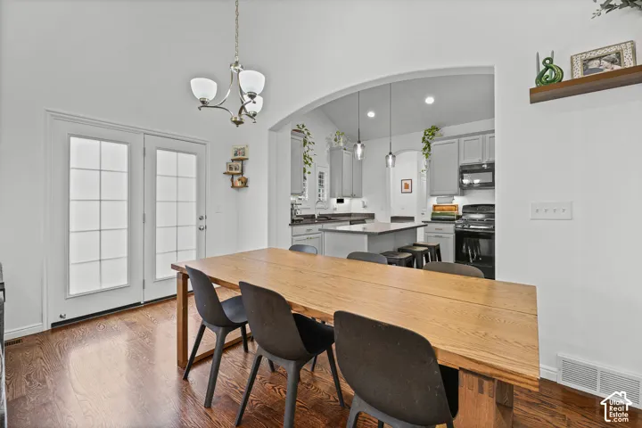 Hardwood-finish flooring, French doors with grid-patterned glass, and an arched entryway