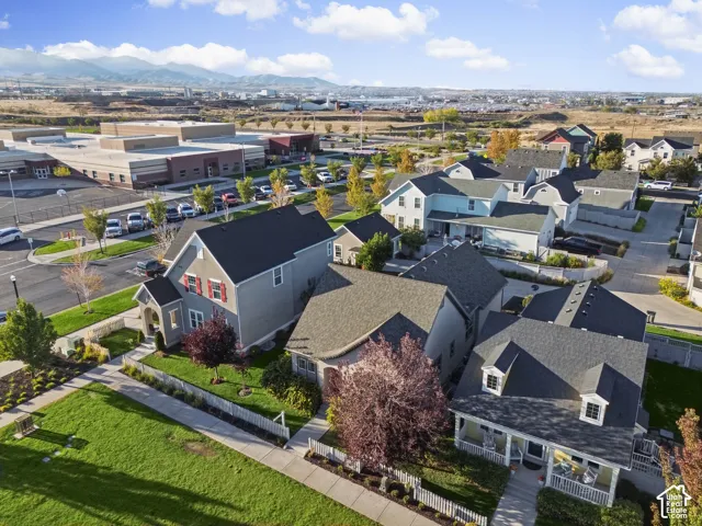 Residential community with diverse architectural styles, visible mountains in the background, and a dedicated community green space