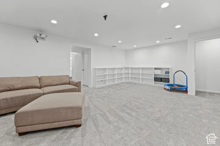 Expansive carpeted room featuring recessed lighting and built-in shelving