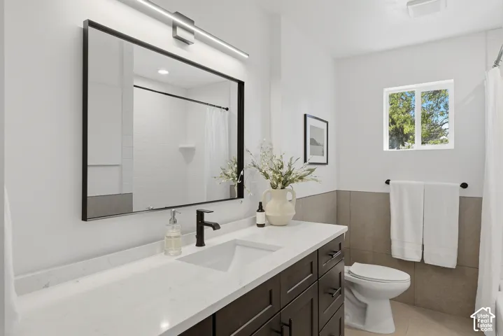 Modern vanity featuring a quartz countertop, integrated rectangular sink, and matte black faucet