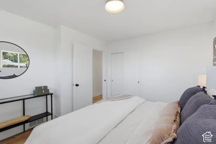 White painted walls with wood-finish flooring, featuring a flush-mount ceiling light fixture, and two panel doors