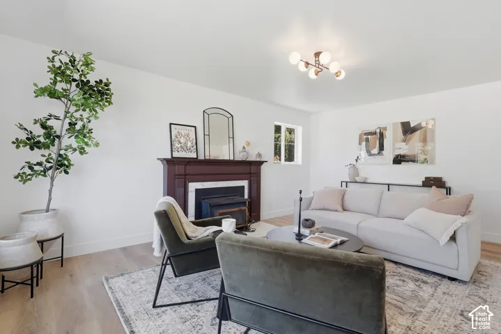 Wood-finish flooring, white walls, and a multi-bulb ceiling fixture illuminate this space