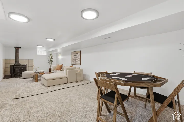 Recessed lighting, wood-burning stove with tile surround, and carpet flooring