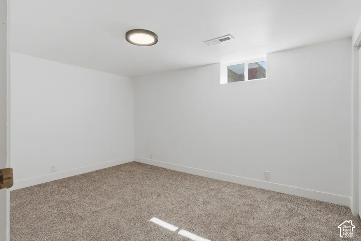 Neutral carpet, recessed window, white walls, and a flush mount ceiling light