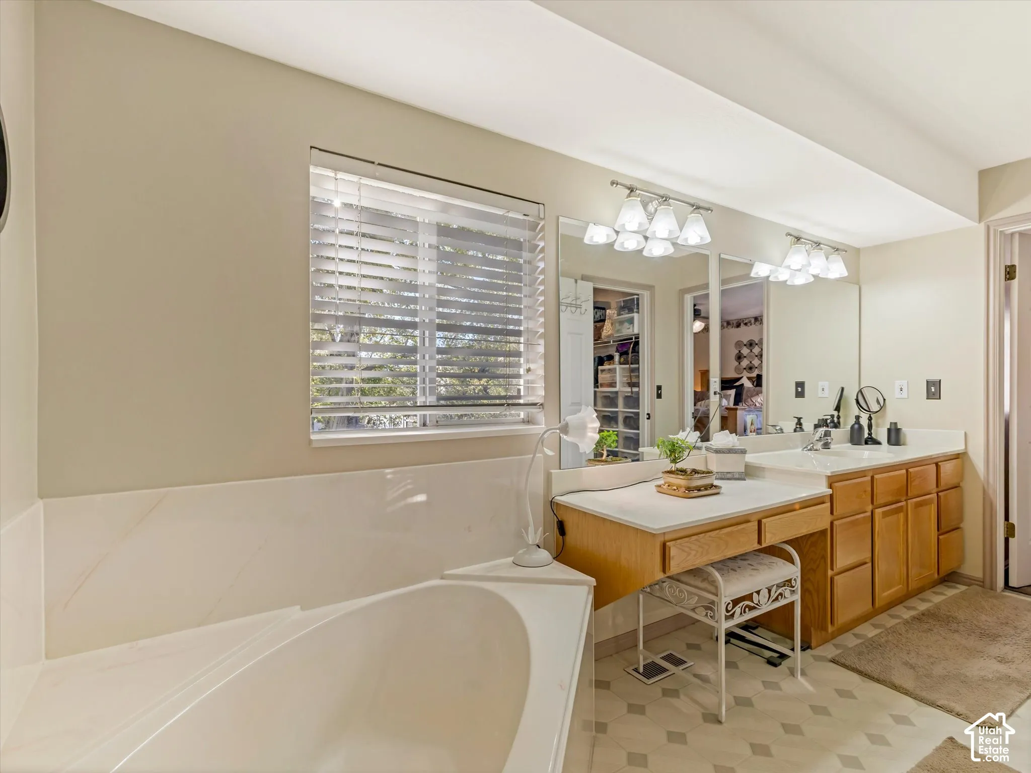 Dual vanity with integrated sinks, ample cabinetry, and an expansive mirror