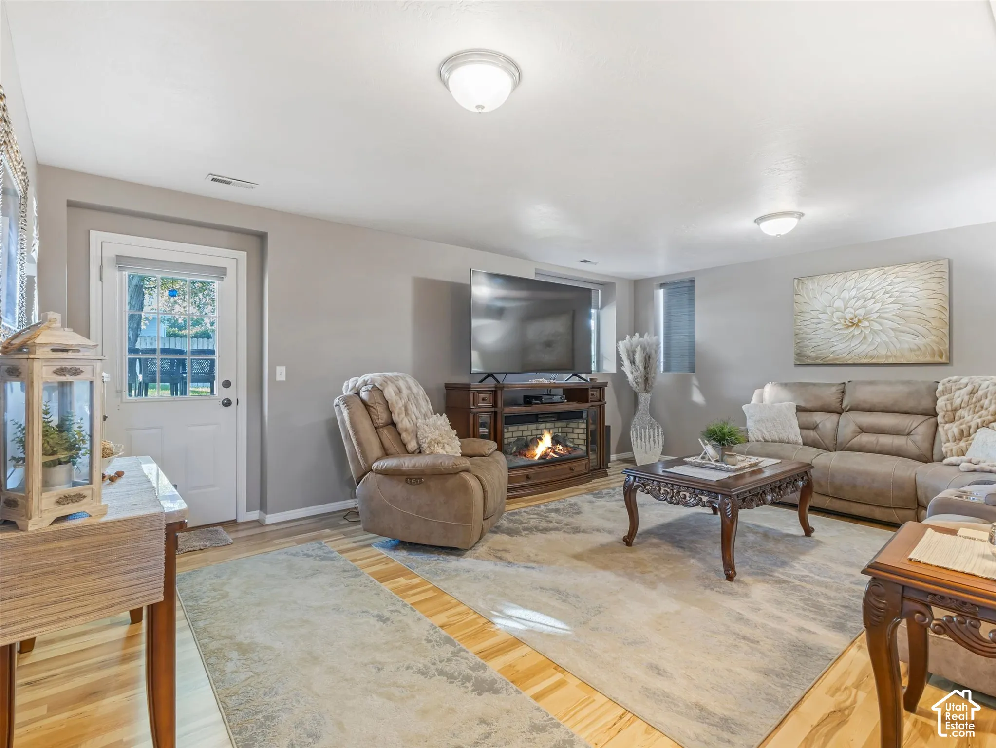 Wood-finish flooring, recessed lighting, and a built-in electric fireplace media console