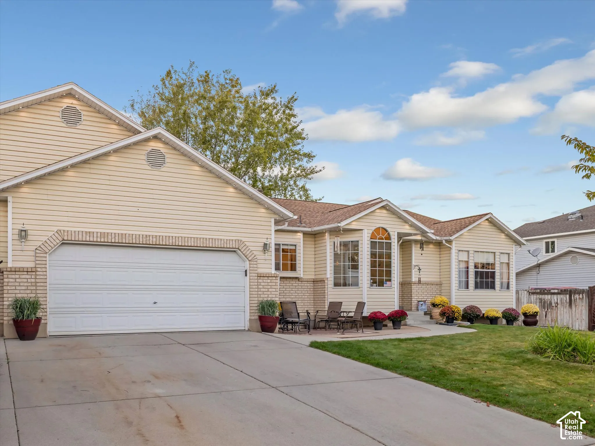 Exterior featuring horizontal siding, brick accents, arched window, and a two-car garage