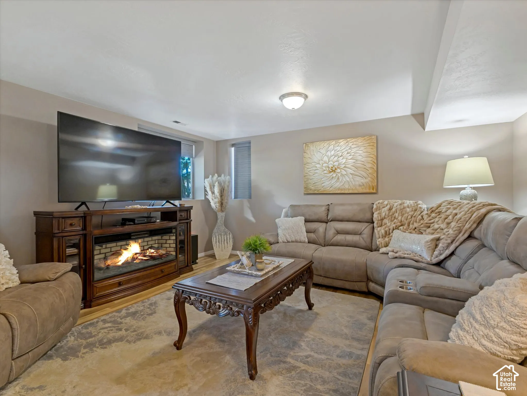 Recessed lighting illuminates this room, featuring light-colored walls and wood-finish flooring