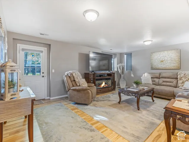 Wood-finish flooring, recessed lighting, and a built-in electric fireplace media console