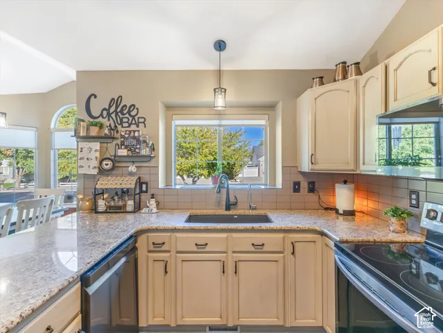 U-shaped kitchen counter with light-toned cabinetry, light-toned countertops, and a tile backsplash