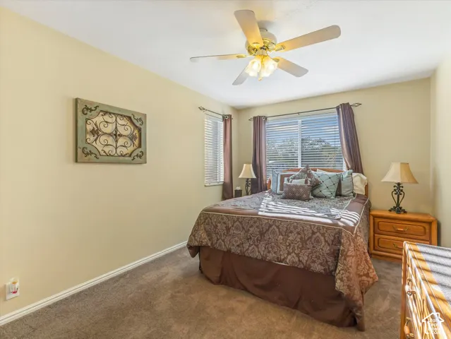 Recessed window with blinds, ceiling fan with integrated lighting, and carpeted flooring