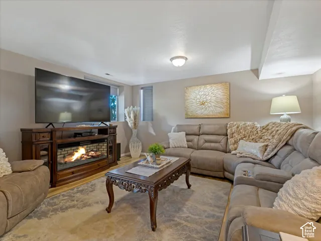 Recessed lighting illuminates this room, featuring light-colored walls and wood-finish flooring