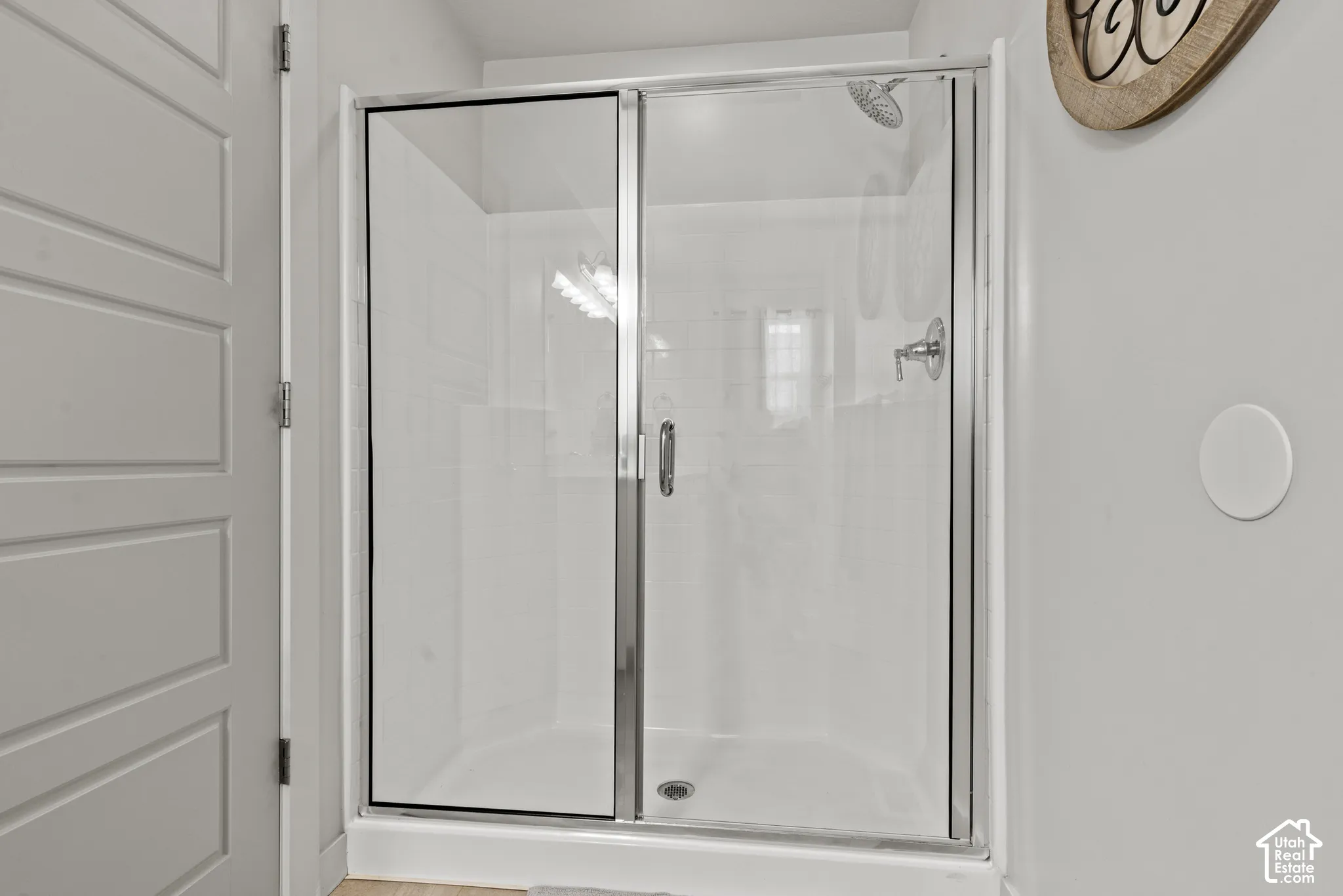 Glass-enclosed shower with chrome fixtures and white subway tile surround