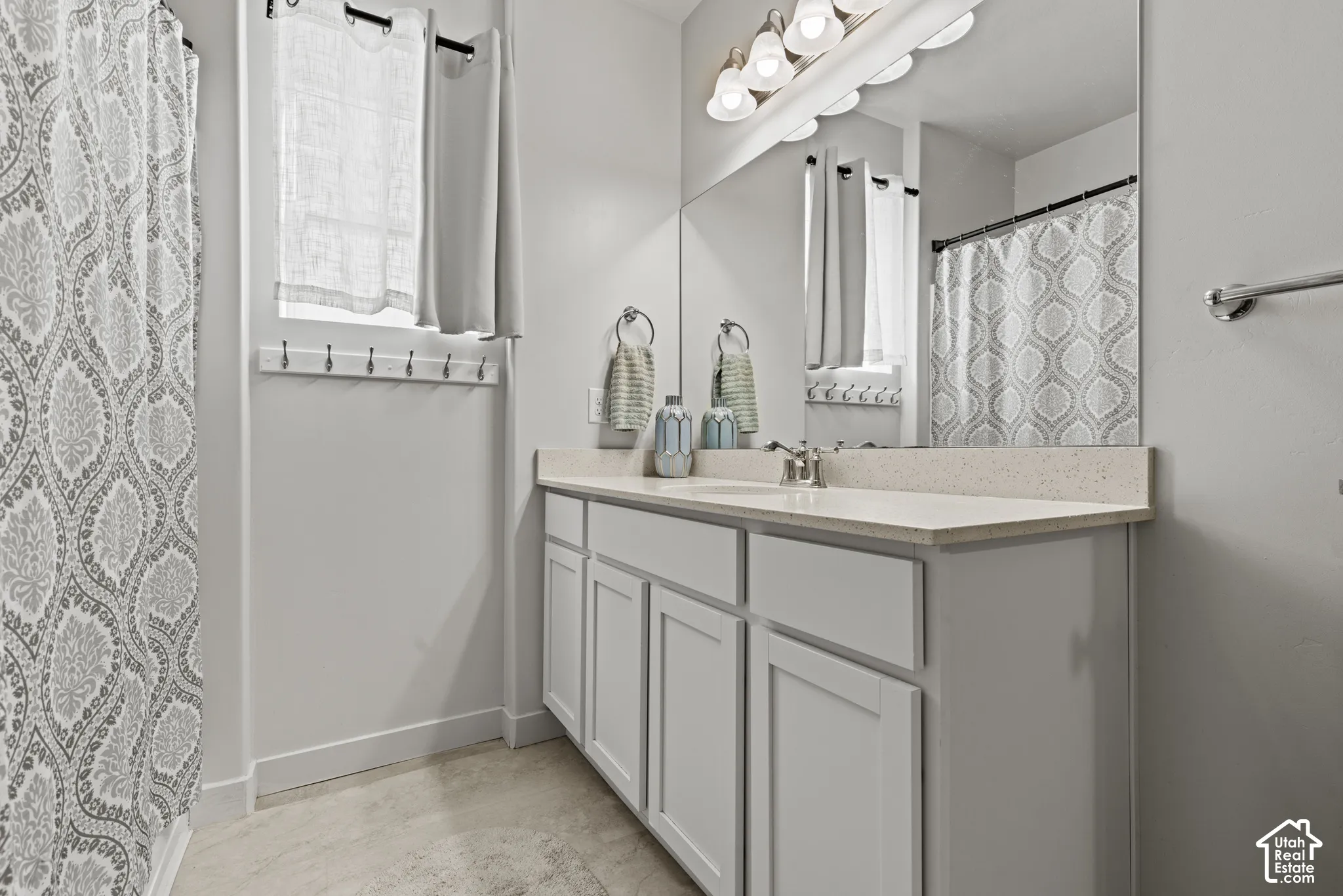 Full-width vanity, light-toned countertop, and undermount sinks