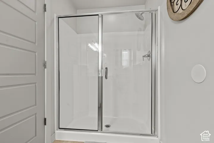 Glass-enclosed shower with chrome fixtures and white subway tile surround