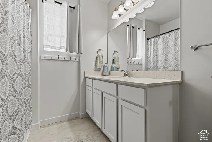 Full-width vanity, light-toned countertop, and undermount sinks