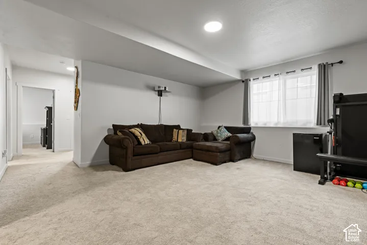 Carpeted room featuring recessed lighting, a window with curtains, and a doorway