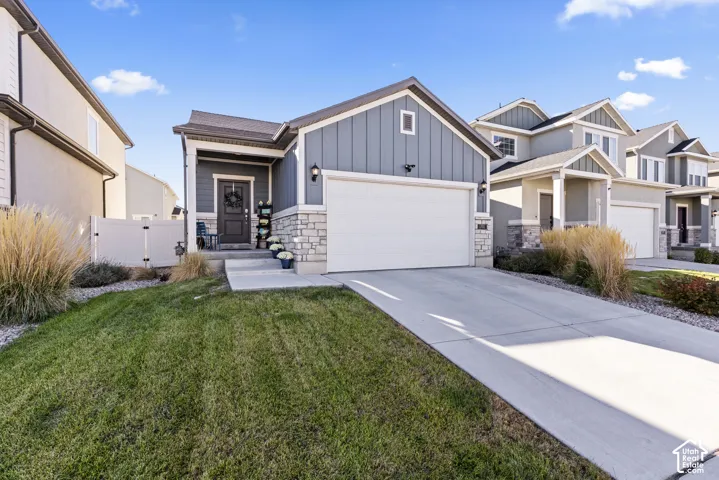 Contemporary exterior featuring horizontal and vertical siding, stone accents, an attached garage, and a concrete driveway