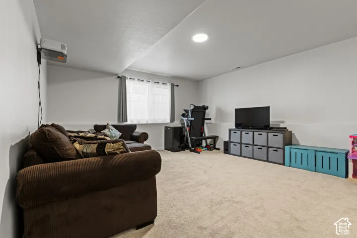 Carpeted flooring, recessed ceiling lighting, and a window with curtains
