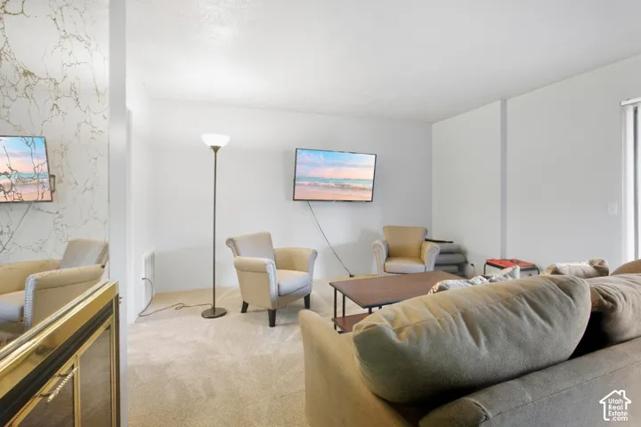 Wall-mounted television with white walls and carpeted flooring