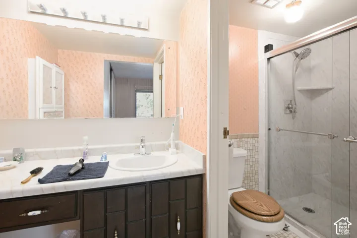 Vanity with a white countertop and integrated sink, dark wood-finish cabinetry, and a large wall-mounted mirror