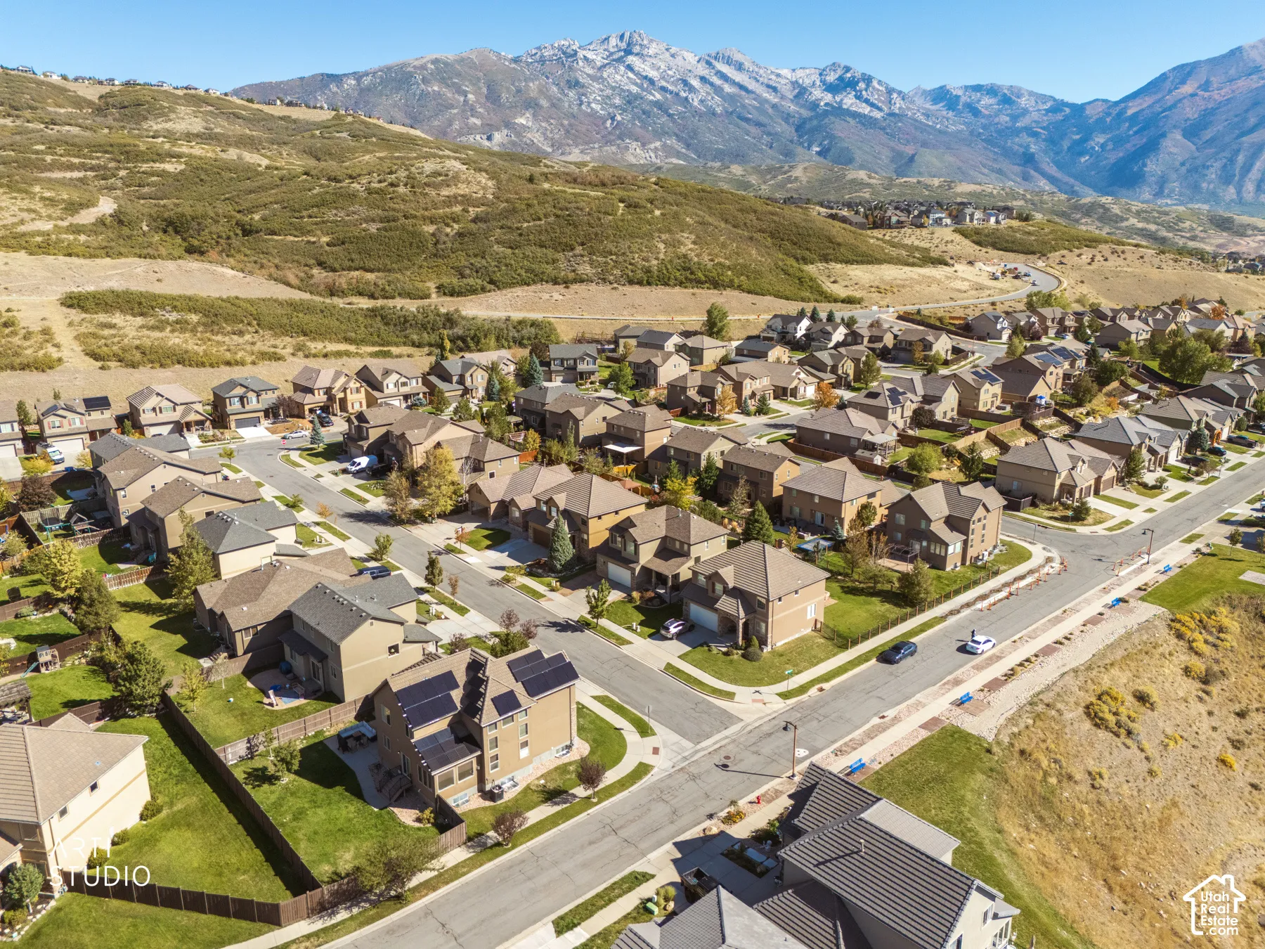 Expansive residential community with established homes, paved streets, and a backdrop of mountainous terrain