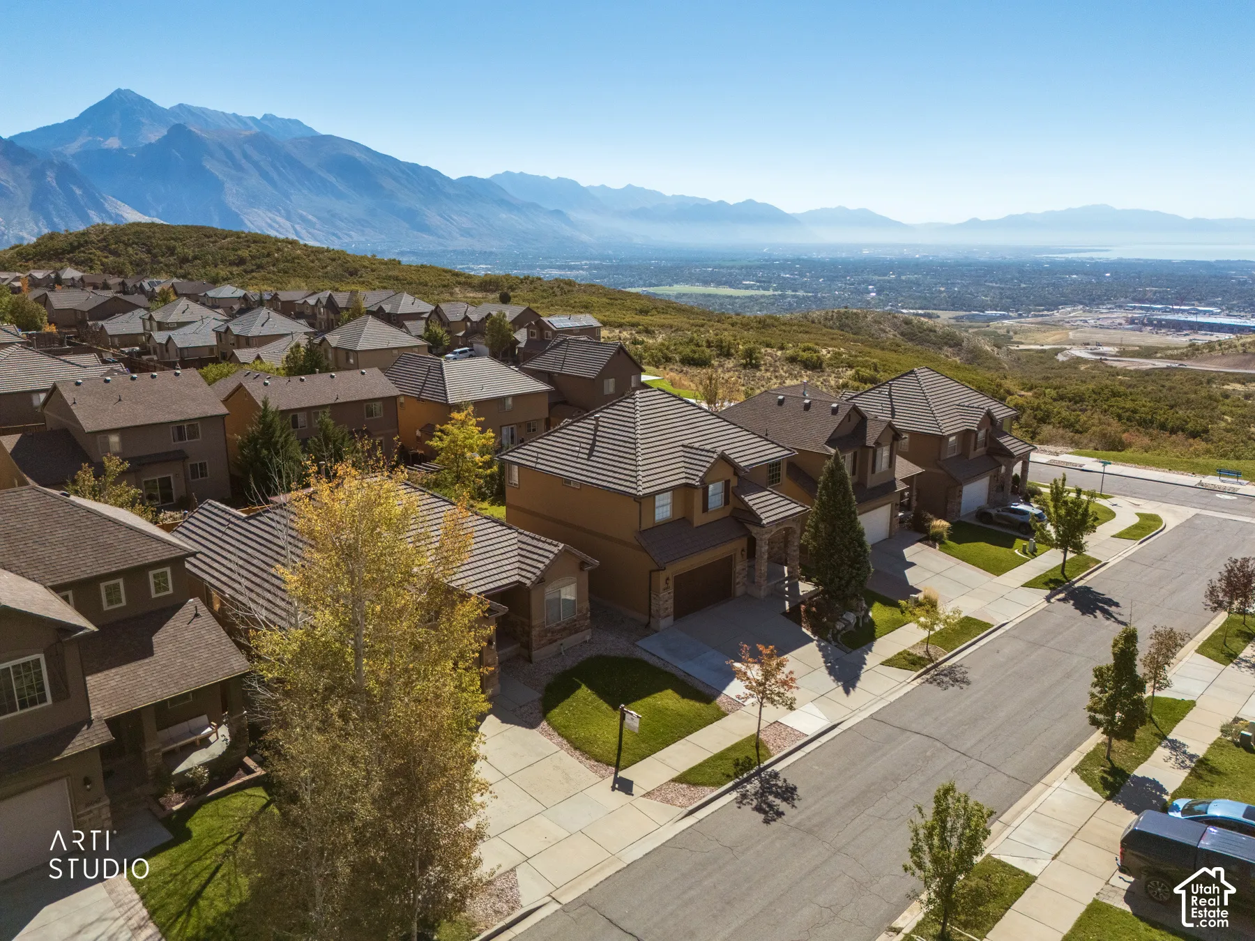 Elevated hilltop residence showcasing contemporary architectural design with brick and stone exterior, multi-level construction, and expansive hardscaped driveway